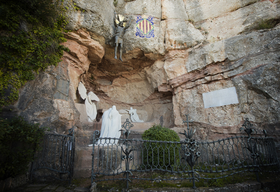 The small Santa Cova sanctuary built into Montserratโs rugged mountainside, surrounded by natural rock formations and lush greenery in Catalunya, Spain