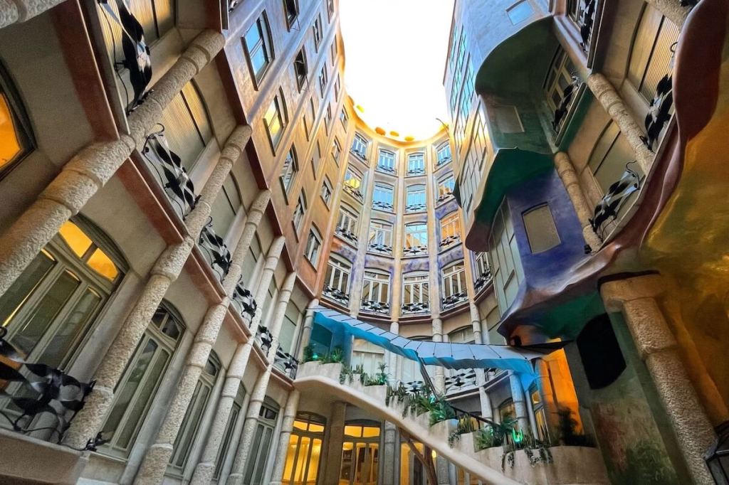 Wavy stone façade of Casa Milà in Barcelona, featuring wrought-iron balconies and organic curves designed by Antoni Gaudí