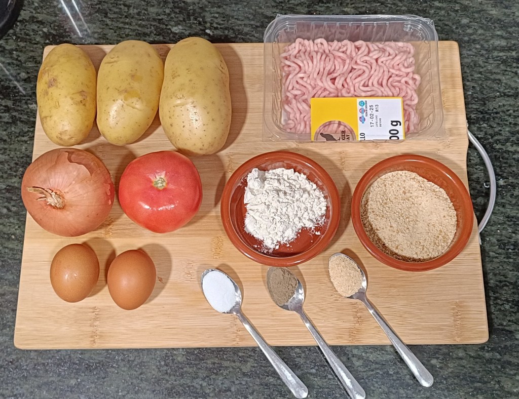 Top-down view of ingredients for Bomba de la Barceloneta: potatoes, minced meat, onion, tomato, eggs, flour, breadcrumbs, salt, pepper, and garlic powder on a wooden board.