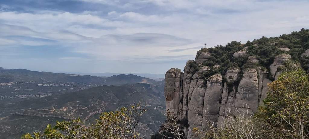 Clear day view from Montserrat mountain revealing a patchwork of fields, villages, and winding roads across the Catalan region