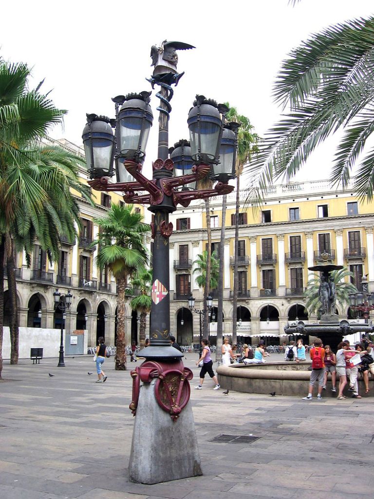 Ornate street lamps in Plaça Reial, Barcelona, designed by Antoni Gaudí, featuring elegant wrought iron and classic lanterns