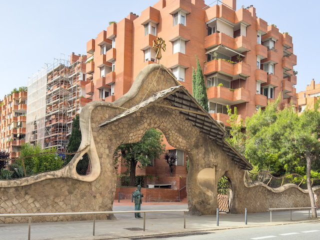 Stone entrance of Portal Miralles in Barcelona, featuring a rustic archway with wrought-iron gates and intricate details blending Gothic and Modernisme styles