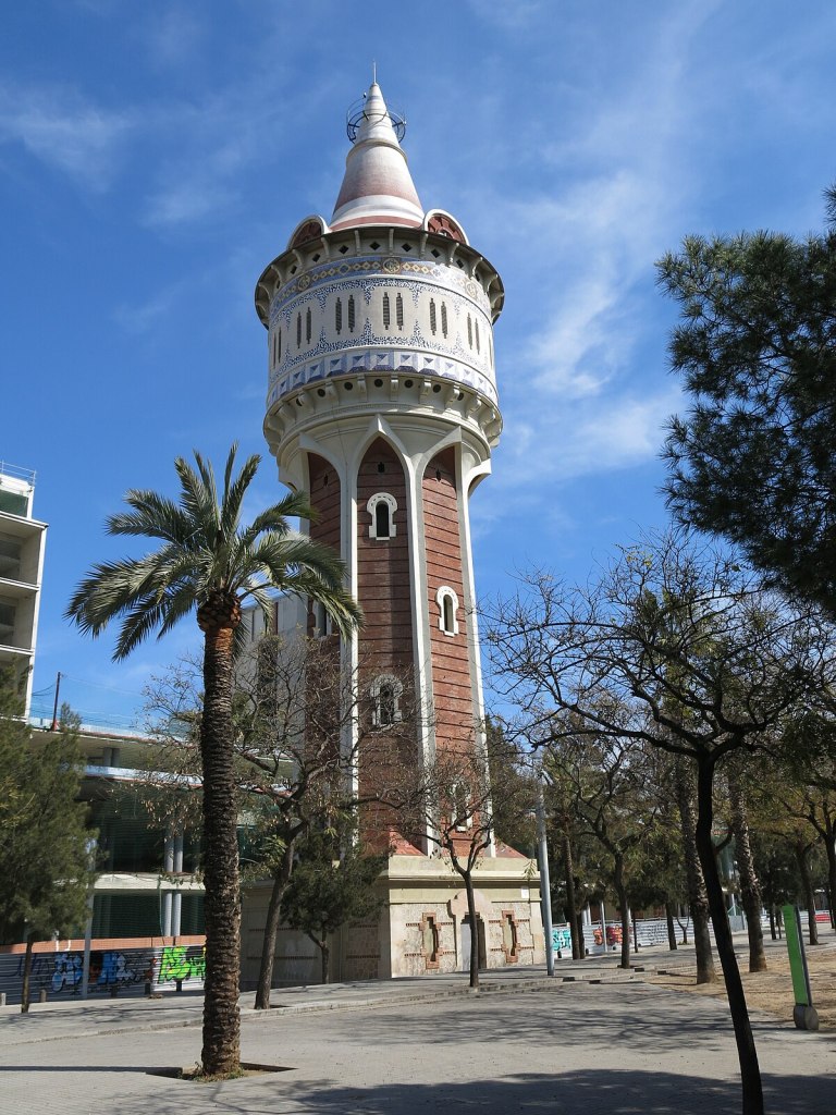 Torre de les Aigües de la Catalana de Gas, a historic water tower in Barcelona featuring red brick construction and a cylindrical shape with decorative arches.