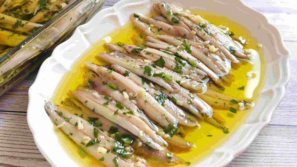 Fresh anchovies marinated in vinegar, garlic, and parsley, served with pan con tomate