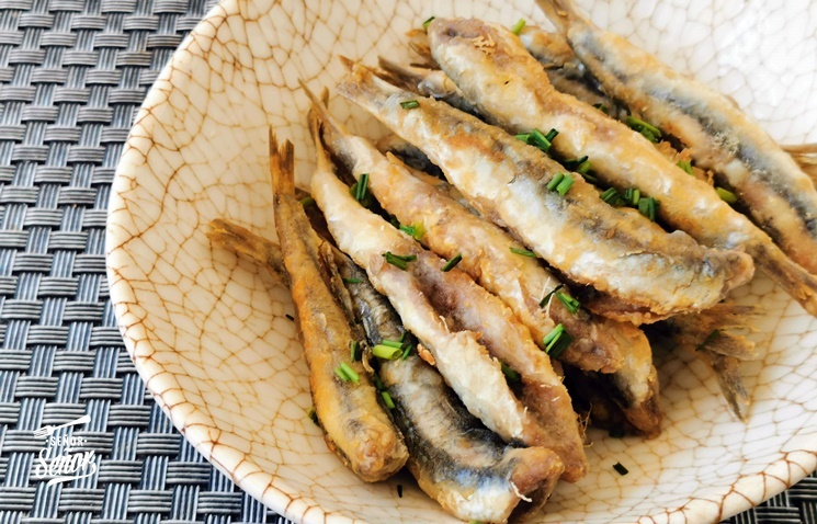 Crispy fried baby fish and sardinas on a stick served at a beachside chiringuito in Andalusia