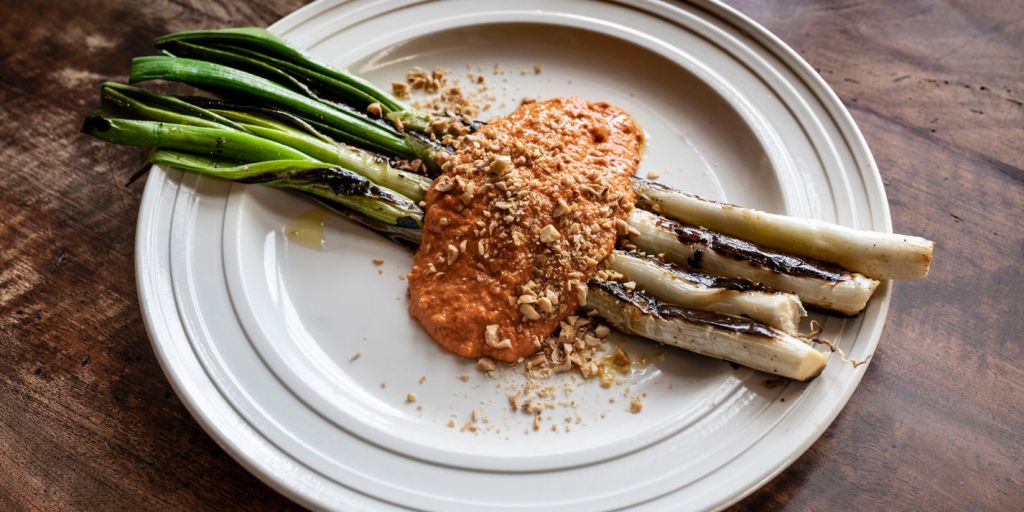 Charred Calçots served with nutty Romesco sauce at a Catalan festival
