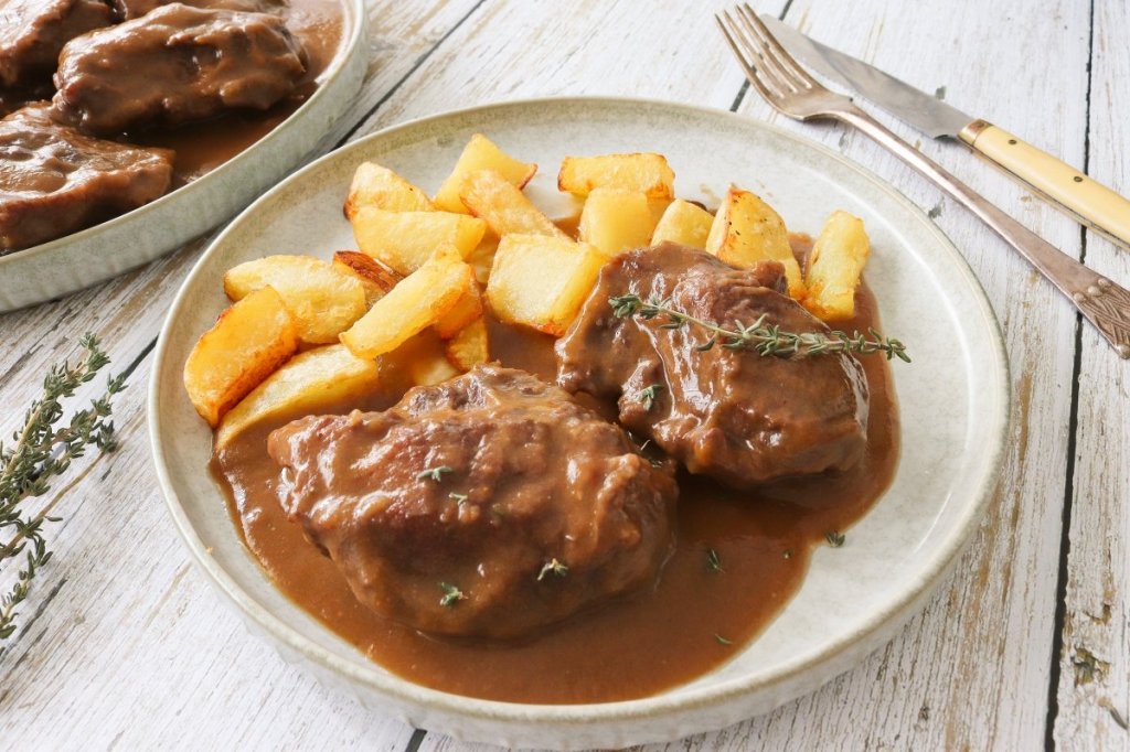 Slow-braised Spanish beef cheeks (carrilleras) in rich sauce, served in a rustic dish