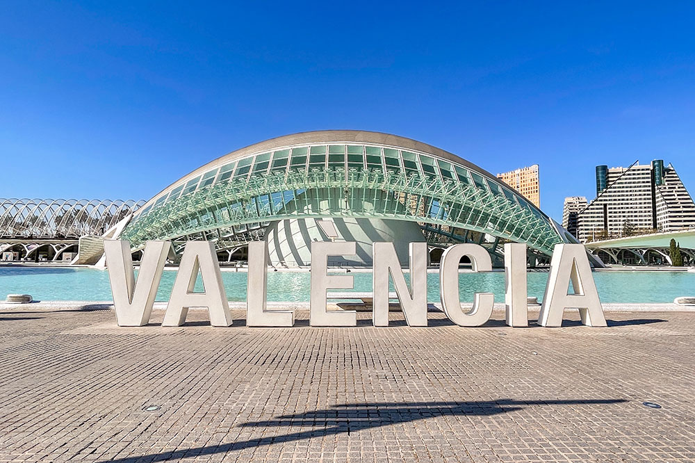 Large white letters spelling 'Valencia' in front of the City of Arts and Sciences complex in Valencia, Spain