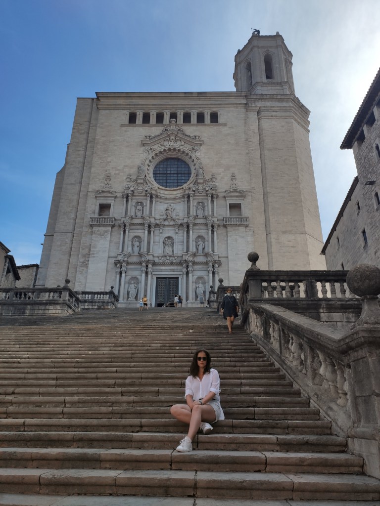 The Girona Cathedral rising above the old town, its grand stone steps leading up to the entrance, a landmark also featured as a filming location in Game of Thrones.