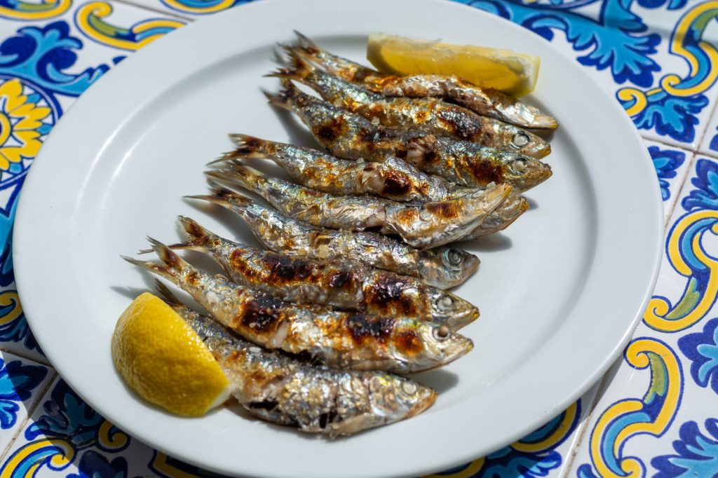Grilled sardines on a stick served fresh at a beachside chiringuito in Andalusia