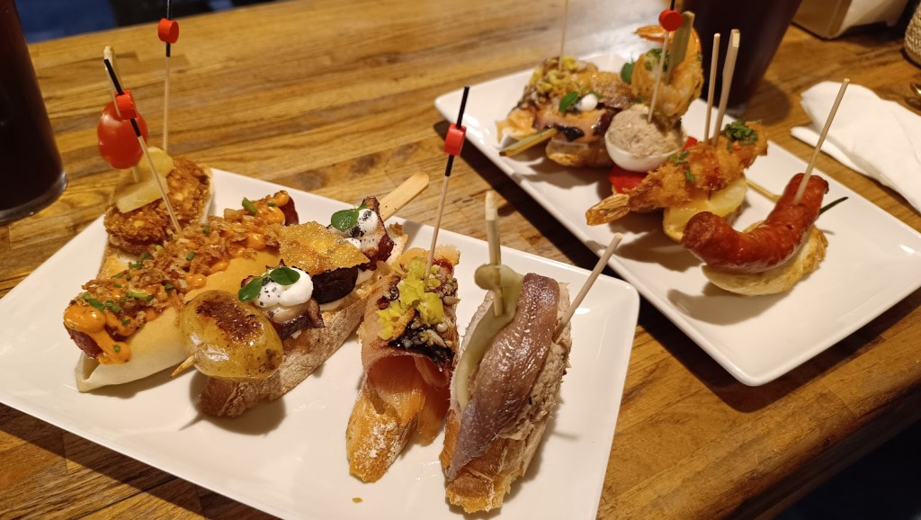 Assorted Basque pintxos on a bar counter, skewered with toothpicks