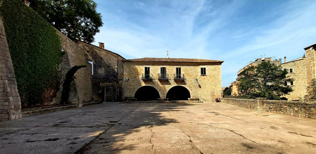 Plaça dels Jurats in Girona, a medieval stone square with historic walls and arches, also used as a filming location for Game of Thrones