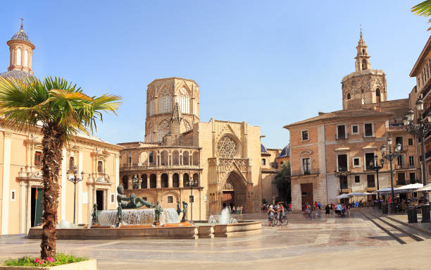 Plaza de la Virgen in Valencia, Spain, with historic buildings, fountains, and lively terraces.