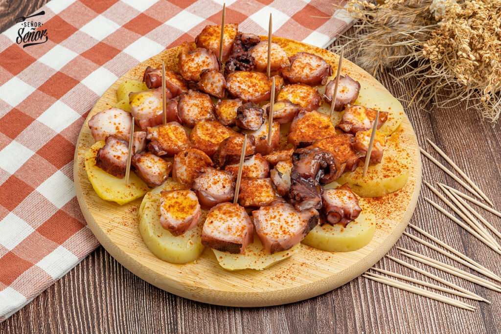 Galician octopus served with paprika, olive oil, and coarse salt on a wooden plate