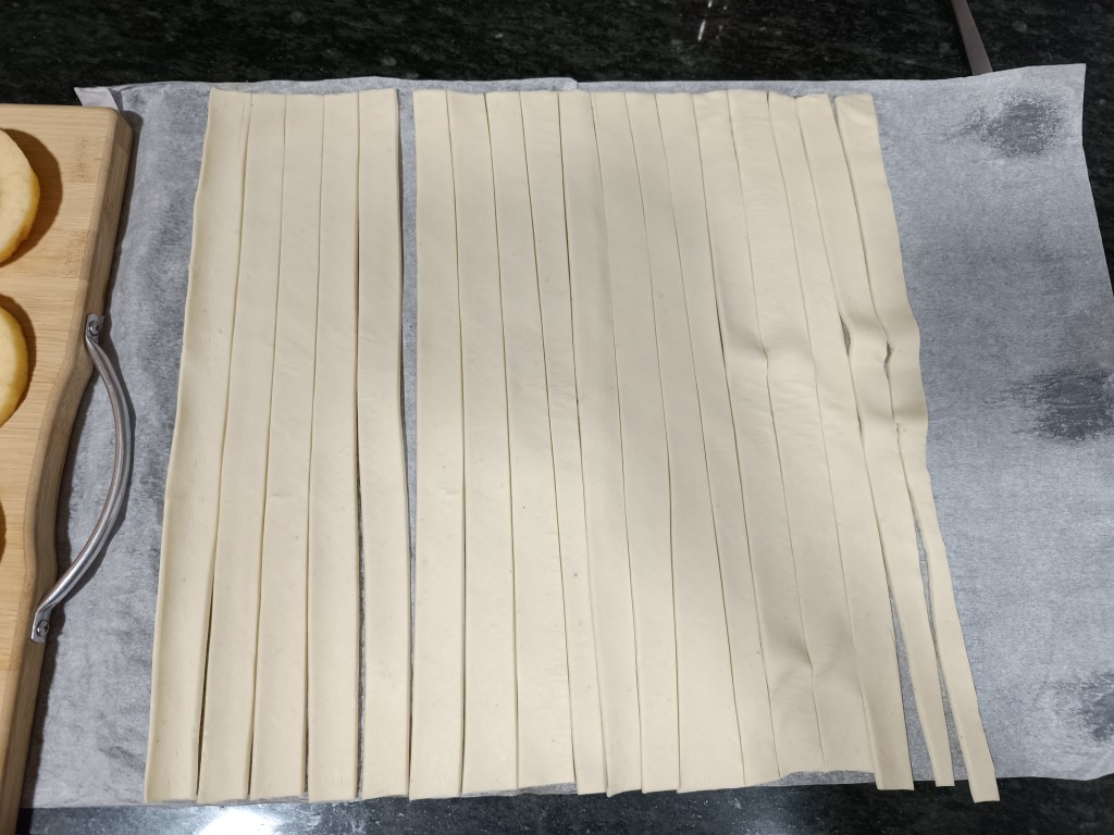 Cutting puff pastry sheet into 1-centimeter strips to wrap around apple rings for TikTok apple doughnuts