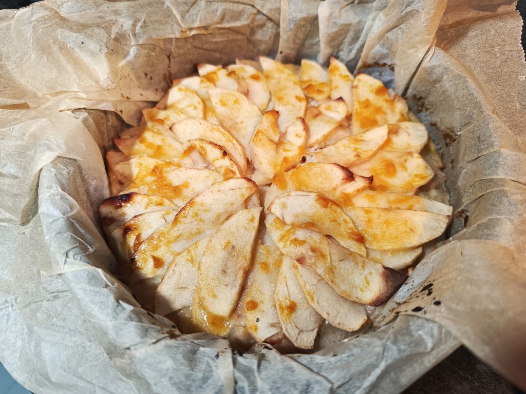 Baked pear pie being brushed with peach jam to give a glossy finish before cooling