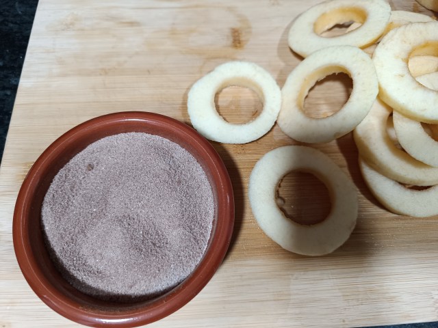 Mixing sugar and cinnamon together in a bowl for apple doughnut coating