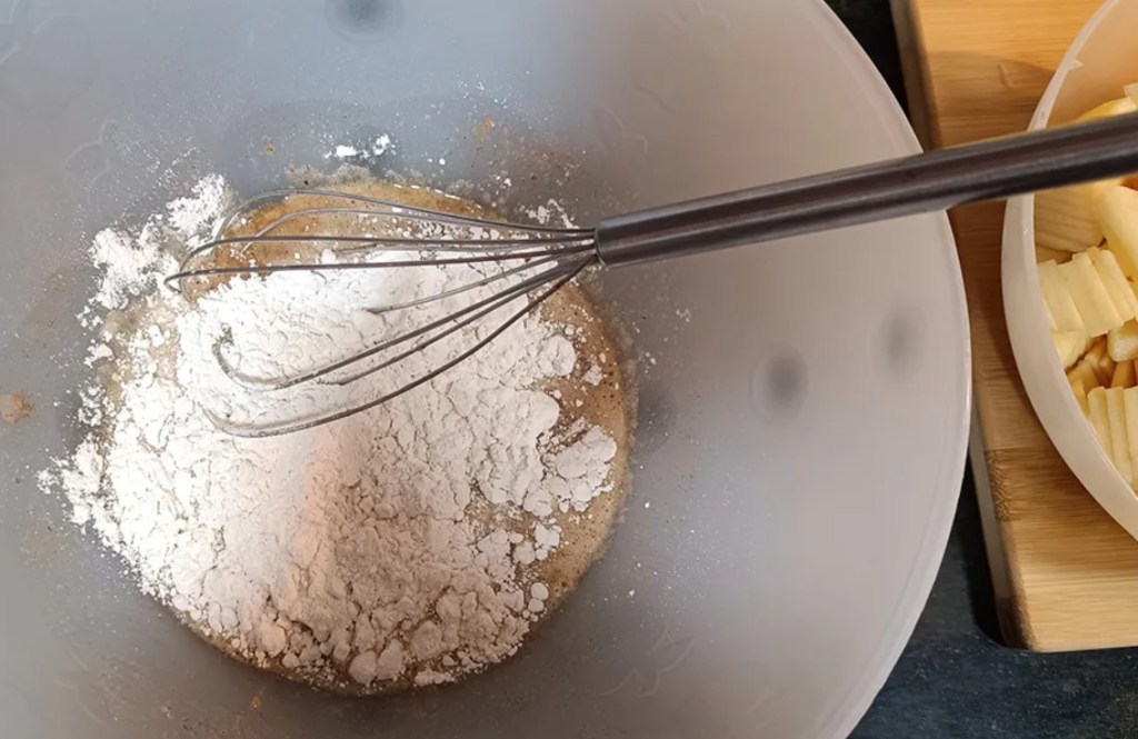 Adding flour, baking soda, and salt to the egg and sugar mixture for pear pie batter.