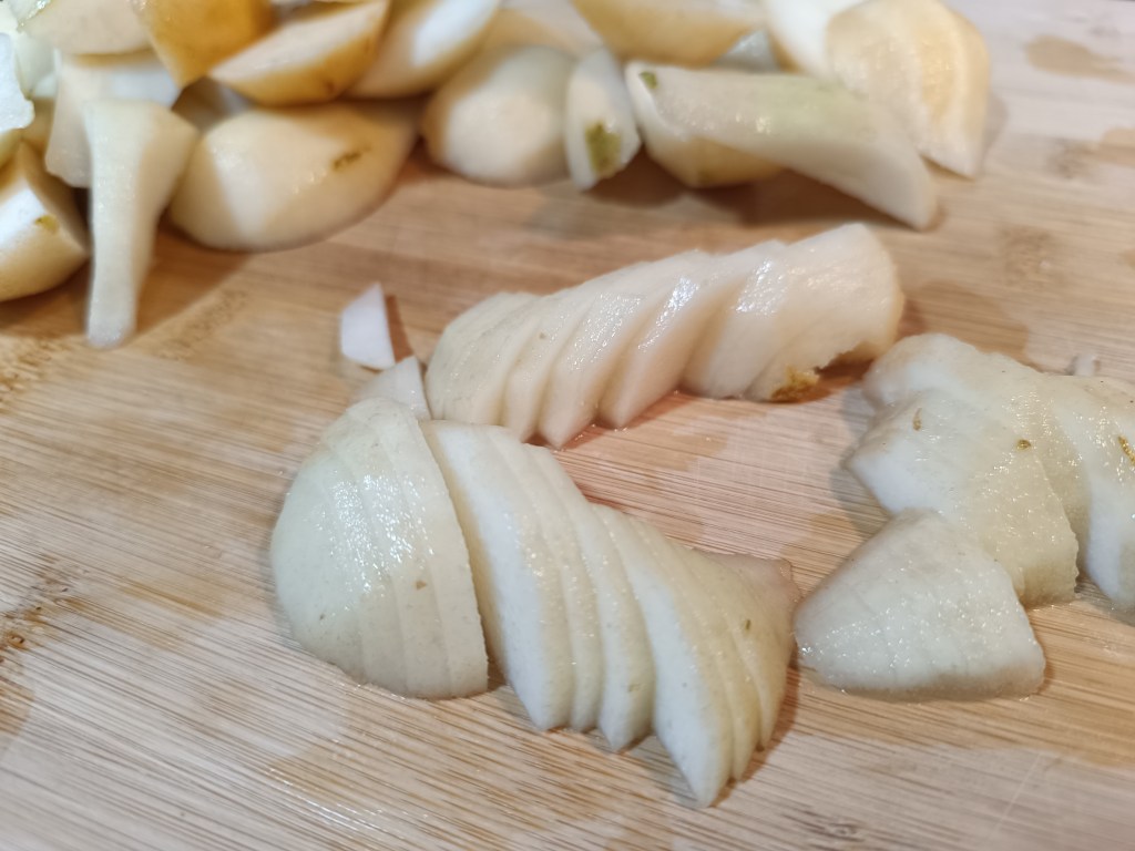 Thin slices of peeled pears ready to be mixed into pear pie filling.