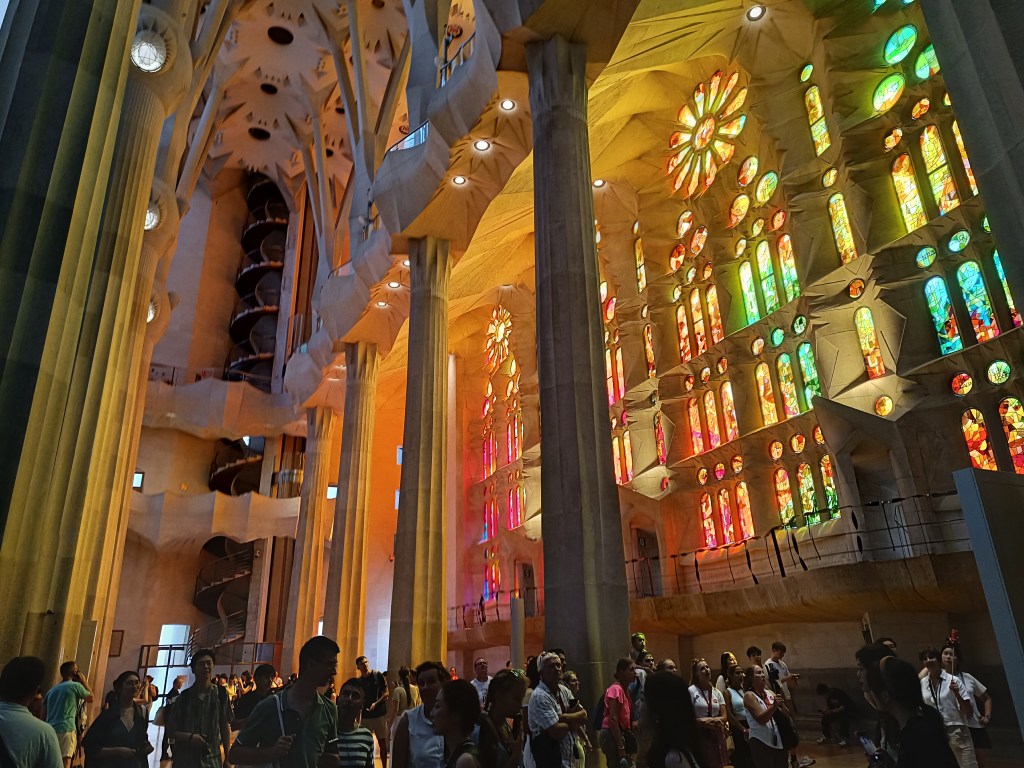 Colorful stained-glass windows inside the Sagrada Familia casting vibrant light patterns across columns and floors