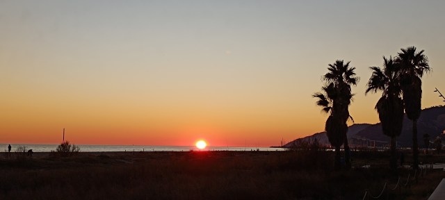 Winter sunset at Castelldefels Beach with the sun setting directly into the sea.