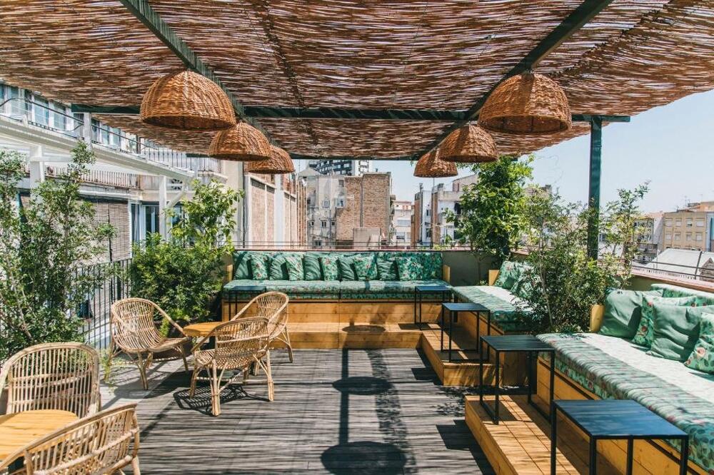 Rooftop terrace at Casa Bonay in Barcelona with relaxed seating, plants, and city views at sunset