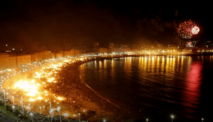 Bonfire burning on a Barcelona beach during the Sant Joan celebration at night.