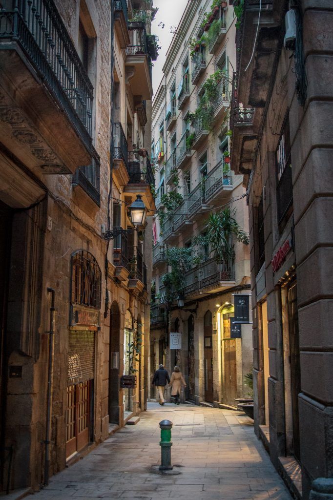 Hidden courtyard in Barcelona’s Gothic Quarter, surrounded by historic stone buildings and arches.