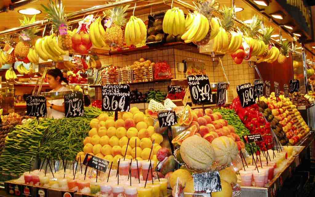 Colorful fruits and vegetables displayed at a busy Barcelona market stall