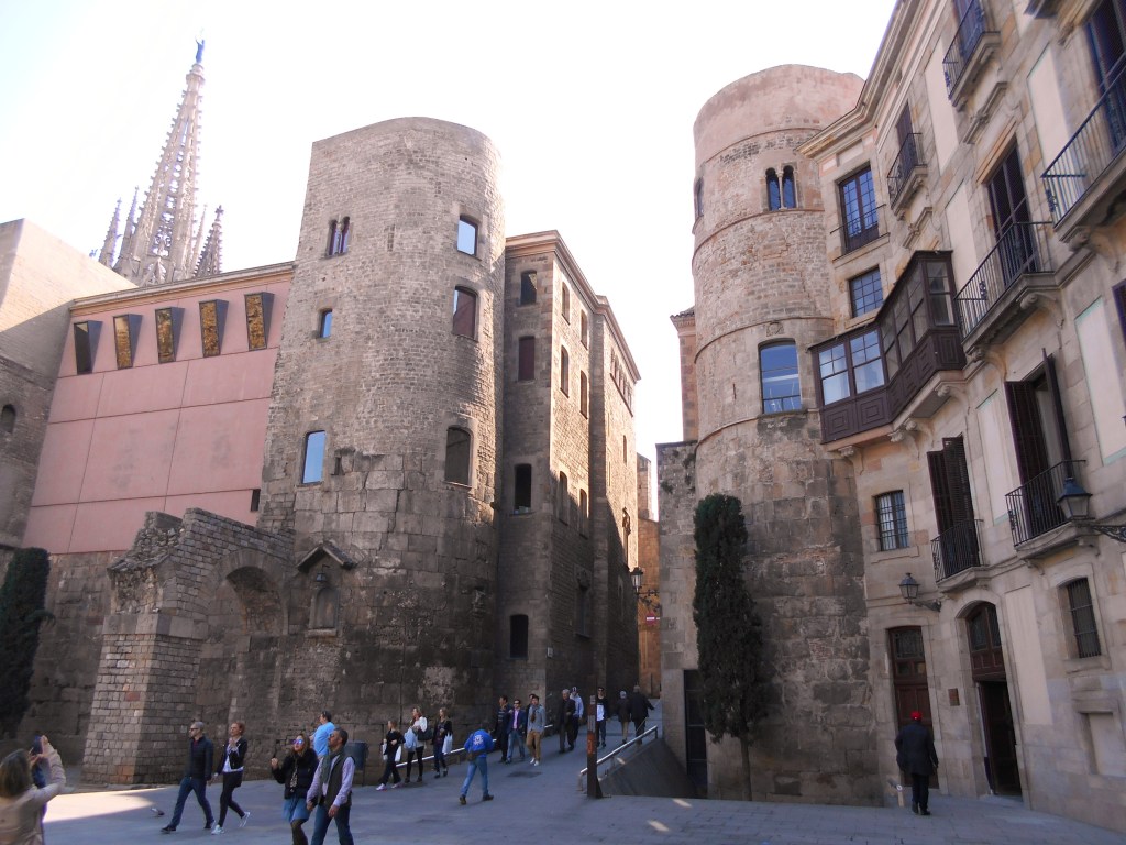 Ancient Roman walls in Barcelona’s Gothic Quarter, visible next to the modern ‘Barcino’ letters, showing the city’s historic roots