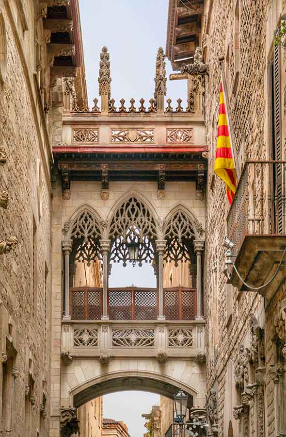 Pont del Bisbe, the iconic arched bridge in Barcelona’s Gothic Quarter, connecting historic buildings over a narrow cobblestone street.