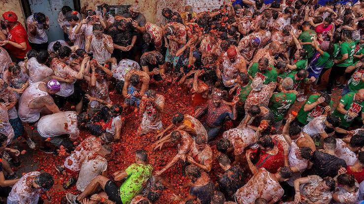 Thousands of people throwing tomatoes at La Tomatina in Spain